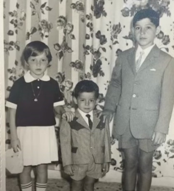 Con su hermana y hermano (él es el menor, el del medio).