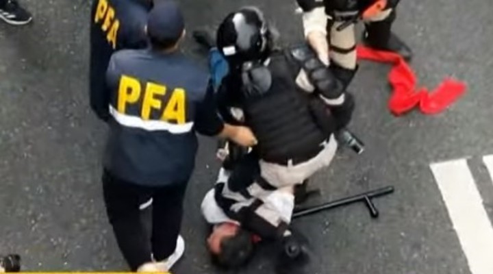Paco Olveira en el piso y retenido por un policía que luego lo liberó.